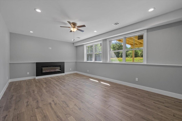 unfurnished living room featuring ceiling fan and wood-type flooring