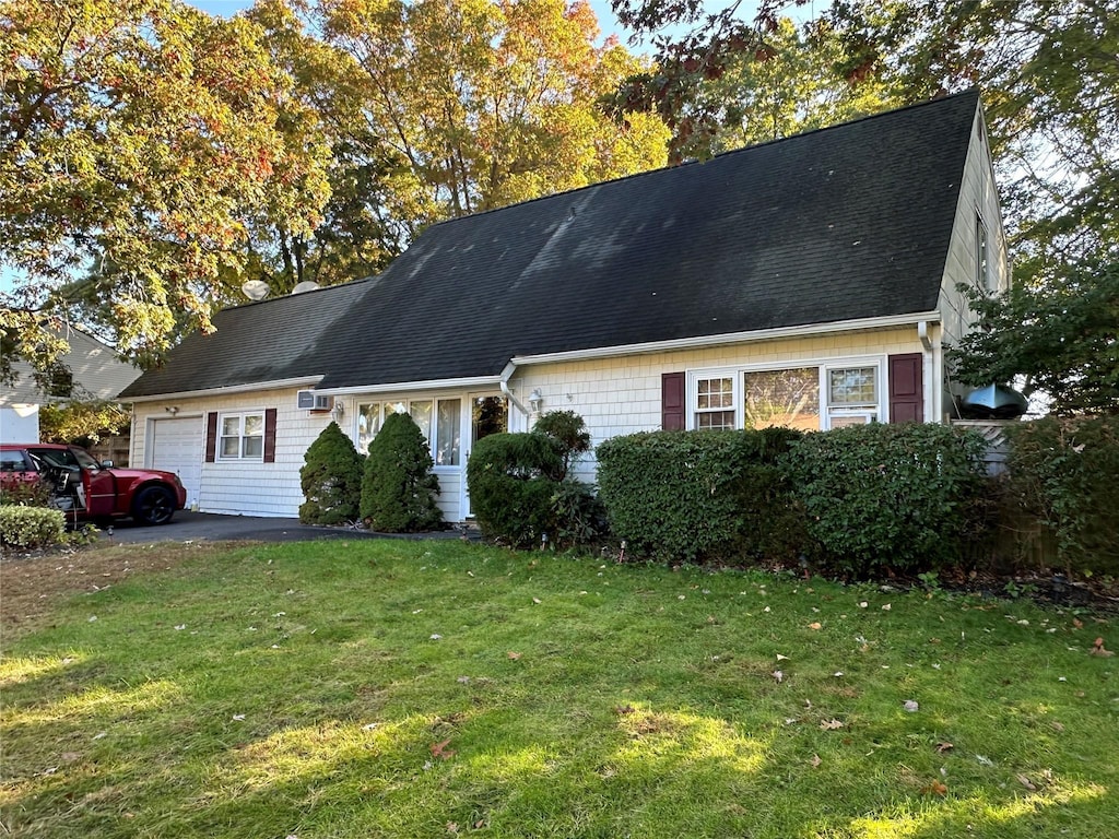 new england style home with a front yard and a garage