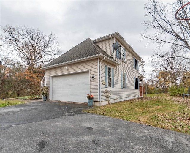 view of side of home with a garage and a lawn