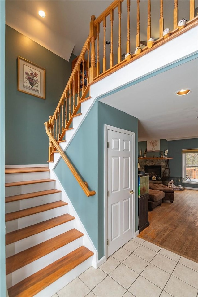 staircase featuring a fireplace and hardwood / wood-style flooring