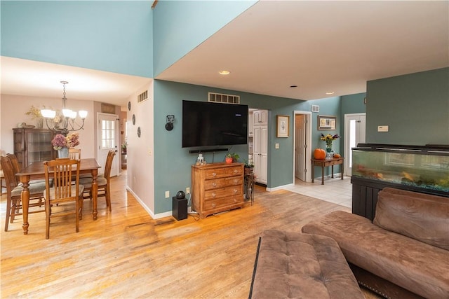 living room featuring light hardwood / wood-style flooring and a notable chandelier