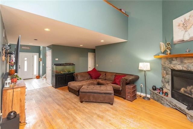 living room with a fireplace and light wood-type flooring