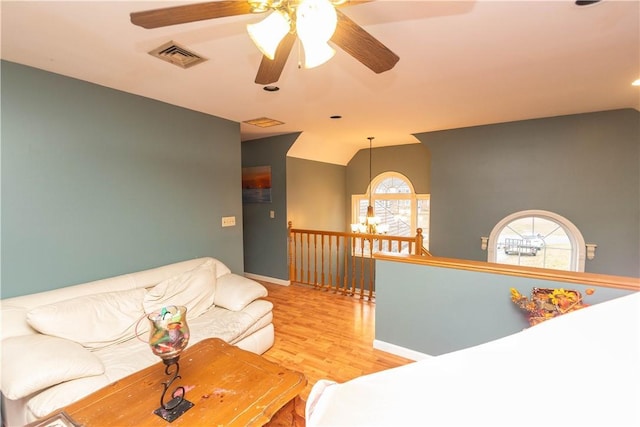 living room with ceiling fan, light hardwood / wood-style floors, and lofted ceiling