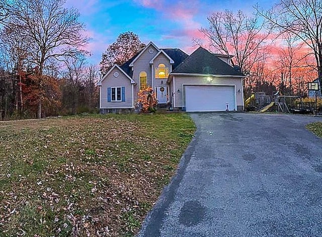 view of front of home with a yard and a garage