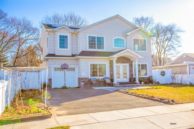 view of front of home with a garage, a front yard, and french doors