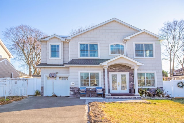 view of front facade with french doors, a garage, and a front lawn