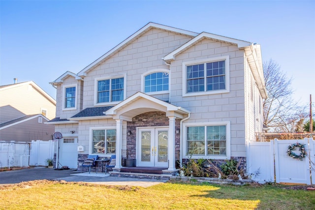 view of front facade with a patio, a front yard, and french doors