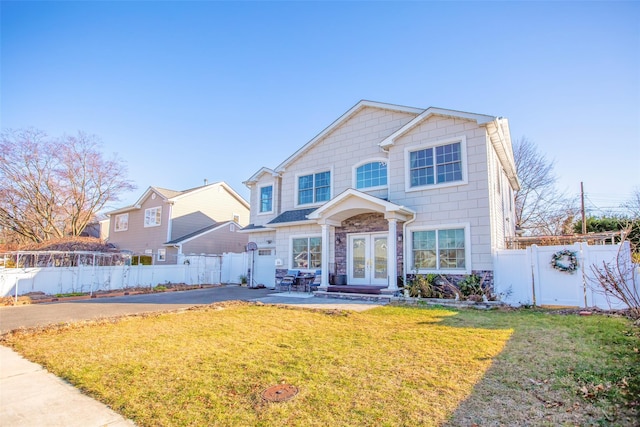 view of front of home with a patio area, a front yard, and french doors