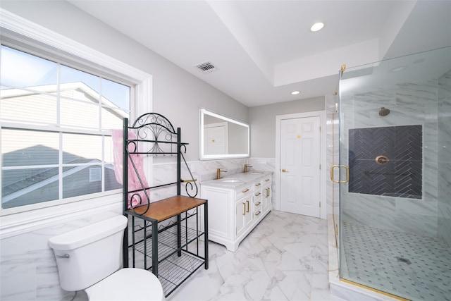 bathroom featuring vanity, toilet, a shower with door, and tile walls