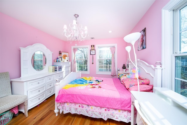 bedroom featuring hardwood / wood-style flooring and an inviting chandelier