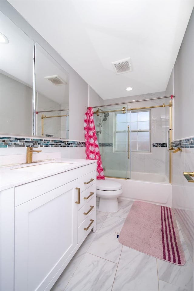 full bathroom with vanity, toilet, tile walls, and bath / shower combo with glass door