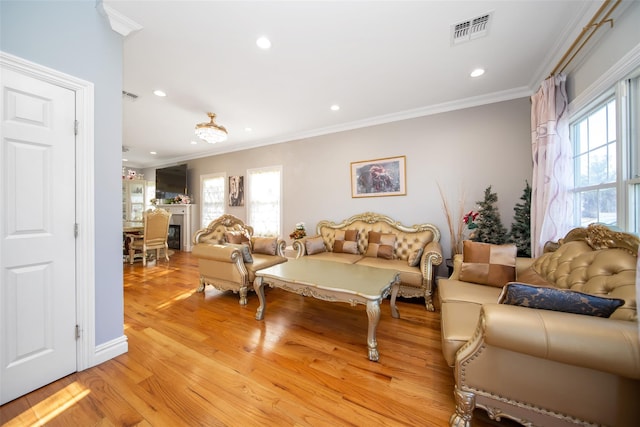 living room with light wood-type flooring and ornamental molding