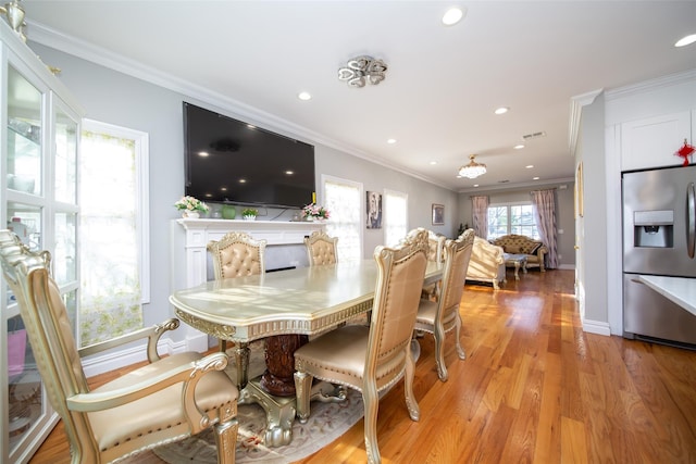 dining area with light hardwood / wood-style floors and ornamental molding