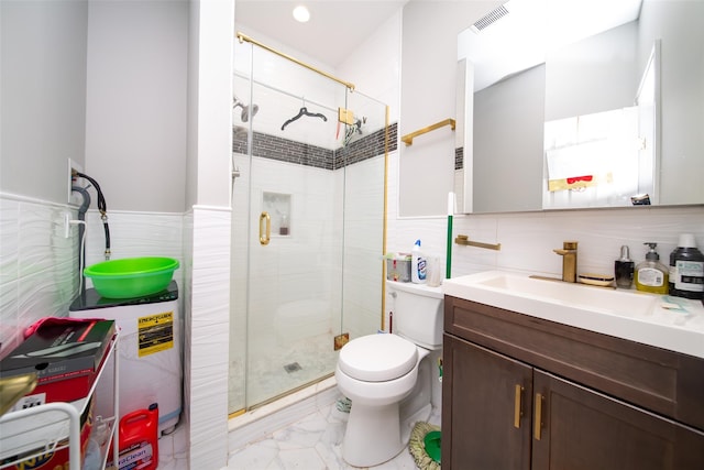 bathroom featuring vanity, toilet, a shower with door, and tile walls