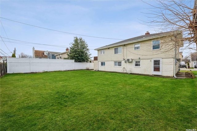 rear view of house featuring a lawn