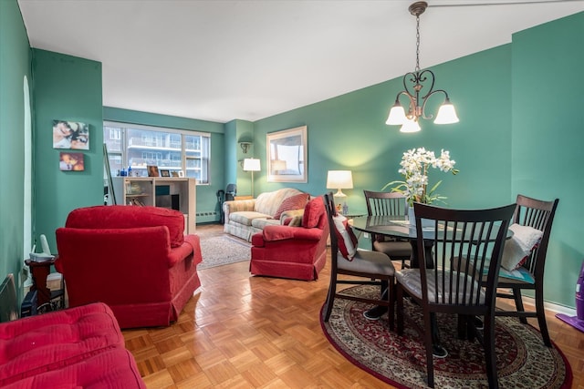 living room featuring a baseboard heating unit, parquet floors, and an inviting chandelier