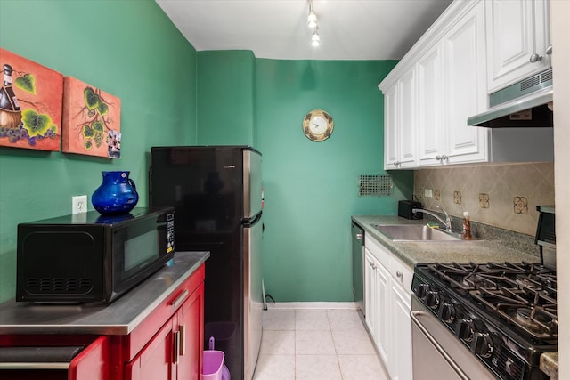 kitchen featuring sink, light tile patterned floors, decorative backsplash, white cabinets, and appliances with stainless steel finishes