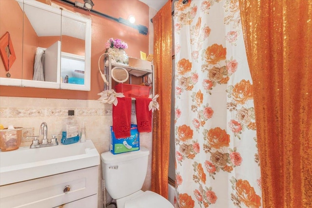 bathroom with vanity, tile walls, and toilet