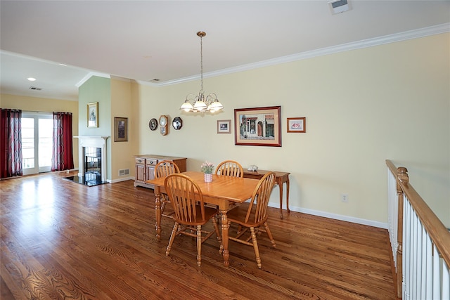 dining area with an inviting chandelier, dark wood-type flooring, and ornamental molding