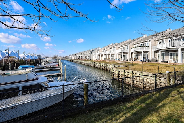 view of dock with a water view and a lawn