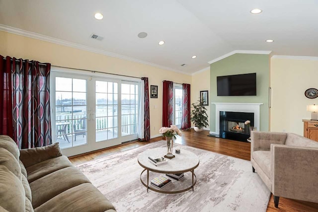 living room with light hardwood / wood-style floors, lofted ceiling, and crown molding