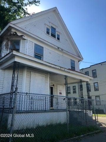 view of front facade featuring covered porch and a fenced front yard
