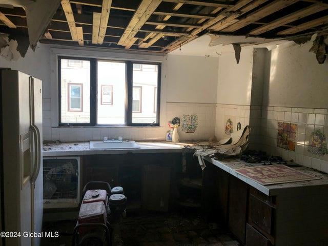 kitchen with fridge with ice dispenser, wainscoting, and a sink