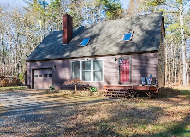 rear view of house with a wooden deck and a garage