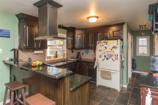 kitchen with white refrigerator, kitchen peninsula, island exhaust hood, and tasteful backsplash