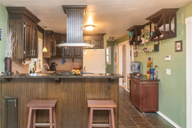 kitchen with a breakfast bar, white refrigerator, kitchen peninsula, and tasteful backsplash