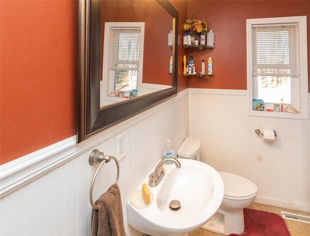 bathroom featuring toilet, sink, and tile patterned flooring