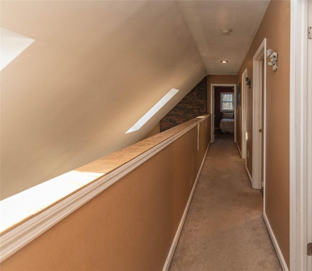 hallway featuring carpet flooring and vaulted ceiling