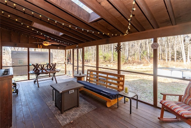 sunroom with beam ceiling, ceiling fan, and wooden ceiling