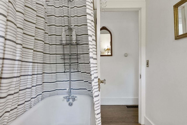 bathroom with hardwood / wood-style flooring and  shower combination