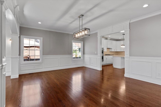 unfurnished dining area featuring dark hardwood / wood-style floors and ornamental molding