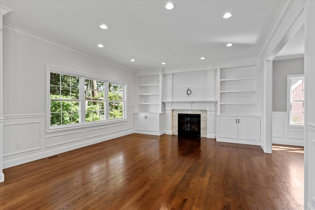 unfurnished living room with dark hardwood / wood-style flooring, built in features, and crown molding