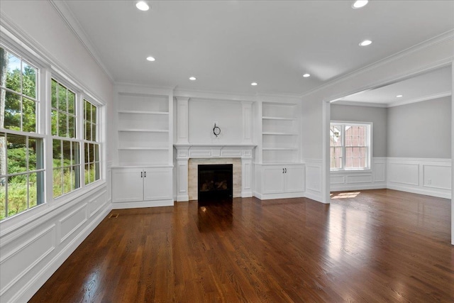 unfurnished living room with built in shelves, ornamental molding, and dark wood-type flooring