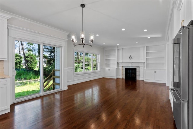 unfurnished living room featuring a high end fireplace, dark hardwood / wood-style floors, built in features, and crown molding