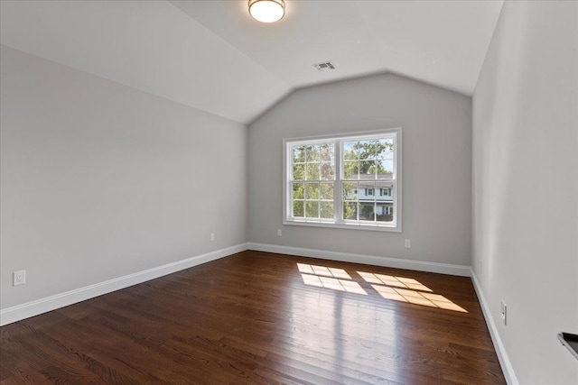 unfurnished room featuring dark hardwood / wood-style flooring and vaulted ceiling