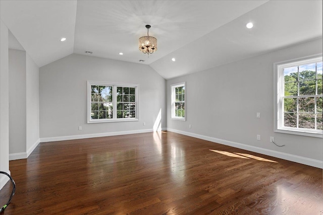 unfurnished living room with dark wood-type flooring, lofted ceiling, and a notable chandelier