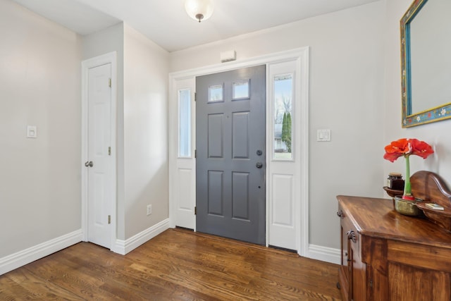 foyer entrance featuring dark wood finished floors and baseboards