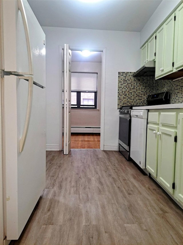 kitchen with green cabinets, light hardwood / wood-style flooring, white fridge, and a baseboard heating unit