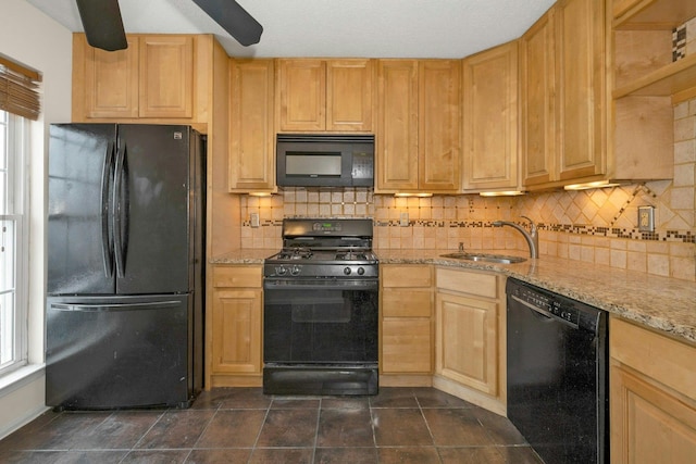 kitchen with light stone countertops, light brown cabinetry, sink, and black appliances