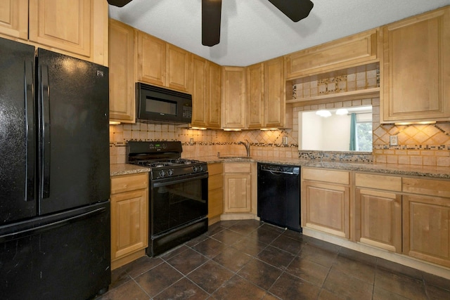 kitchen featuring black appliances, light brown cabinets, light stone counters, and backsplash