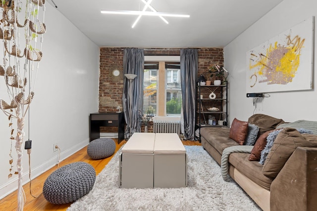 living room featuring hardwood / wood-style flooring and brick wall