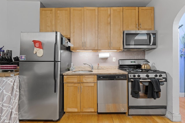 kitchen featuring sink, stainless steel appliances, light brown cabinets, and light hardwood / wood-style floors