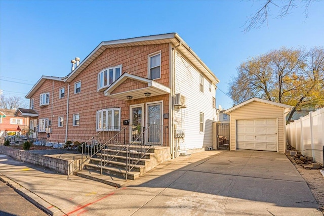 view of front facade featuring an AC wall unit, an outdoor structure, and a garage