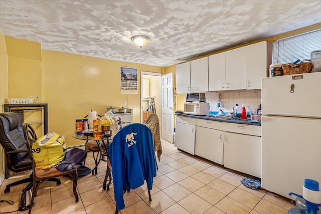 135-07 223rd St, Laurelton, NY 11413 - kitchen with white appliances, dark countertops, white cabinetry, light tile patterned flooring, and a textured ceiling