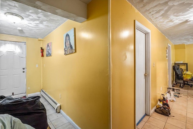 foyer entrance with baseboard heating and light tile patterned floors