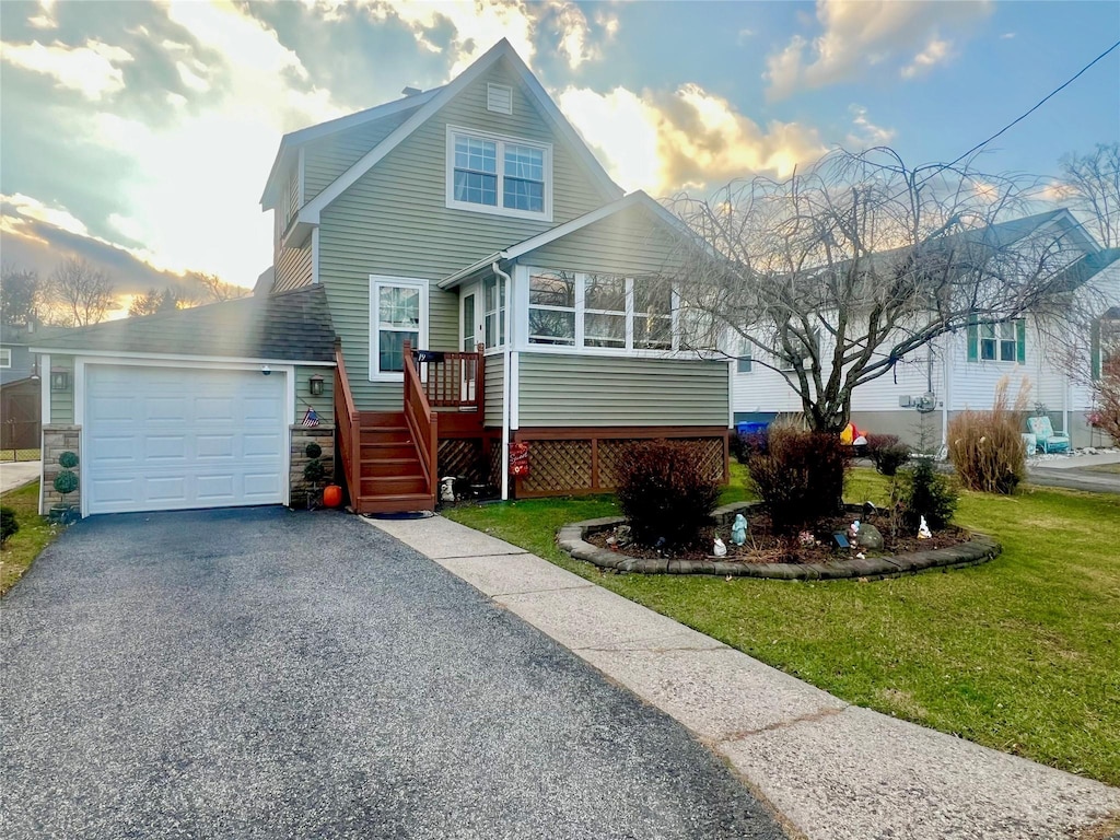 front facade with a yard and a garage